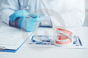 Dentist with denture learning how to teeth At dentistÃâs office photo